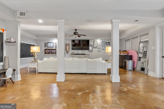 living room featuring concrete floors and ornate columns