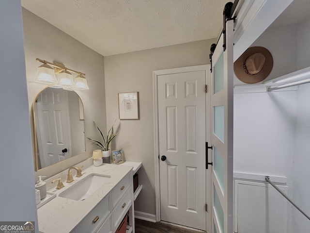 bathroom featuring a textured ceiling and vanity