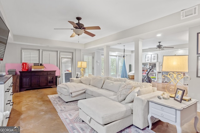 living room featuring ornate columns, ceiling fan, concrete floors, and visible vents