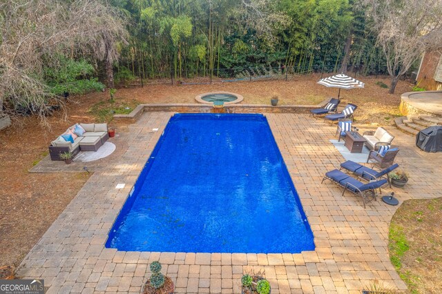 view of pool featuring a playground and an in ground hot tub