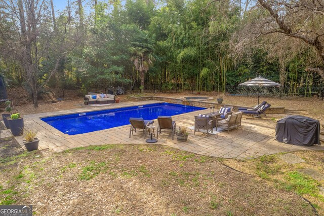 view of pool featuring a playground, an in ground hot tub, and a patio area