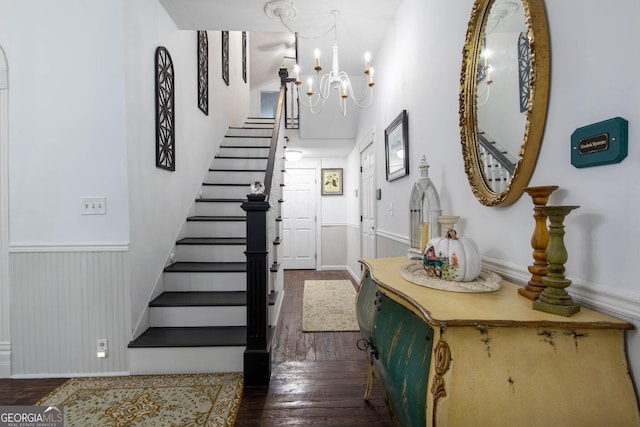 stairs with an inviting chandelier and hardwood / wood-style floors