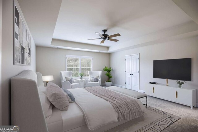 bedroom featuring a raised ceiling, ceiling fan, and carpet