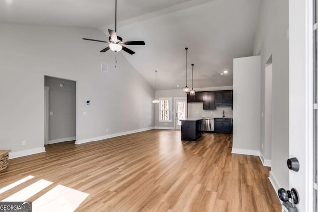 unfurnished living room featuring sink, ceiling fan with notable chandelier, light hardwood / wood-style flooring, and high vaulted ceiling