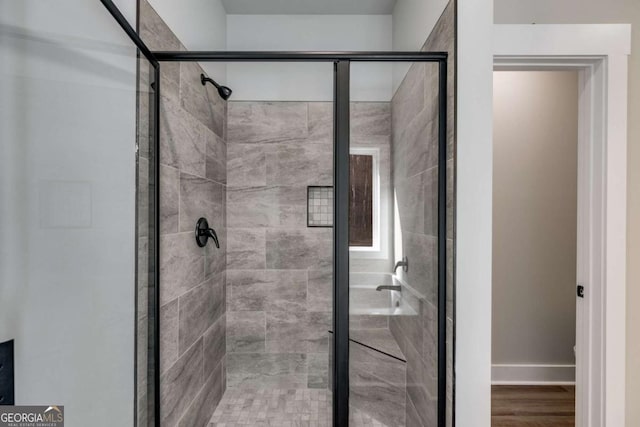 bathroom featuring a shower with door and hardwood / wood-style floors