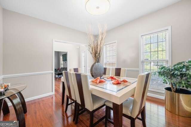 dining space with wood-type flooring