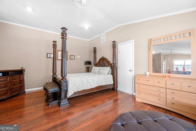 bedroom with vaulted ceiling, ornamental molding, and dark hardwood / wood-style floors