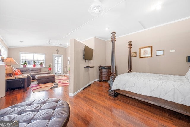 bedroom featuring crown molding, hardwood / wood-style flooring, and vaulted ceiling