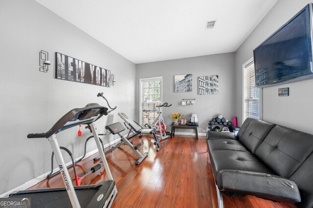 exercise area featuring a healthy amount of sunlight and dark wood-type flooring