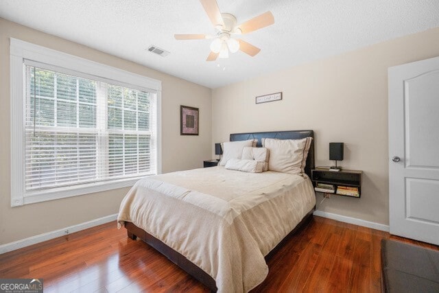 bedroom with dark hardwood / wood-style floors and ceiling fan