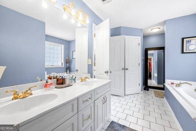 bathroom with tile patterned floors, a bathtub, and vanity