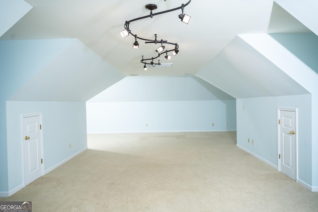 additional living space featuring vaulted ceiling and light colored carpet