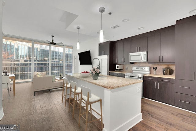 1080 Peachtree St NE Unit 804, Atlanta, GA 30309 - kitchen with expansive windows, visible vents, appliances with stainless steel finishes, wood-type flooring, and a sink