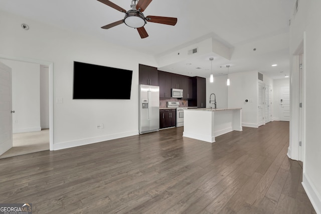 unfurnished living room with ceiling fan, dark hardwood / wood-style flooring, and sink