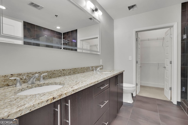 bathroom featuring vanity, toilet, tile patterned floors, and a shower