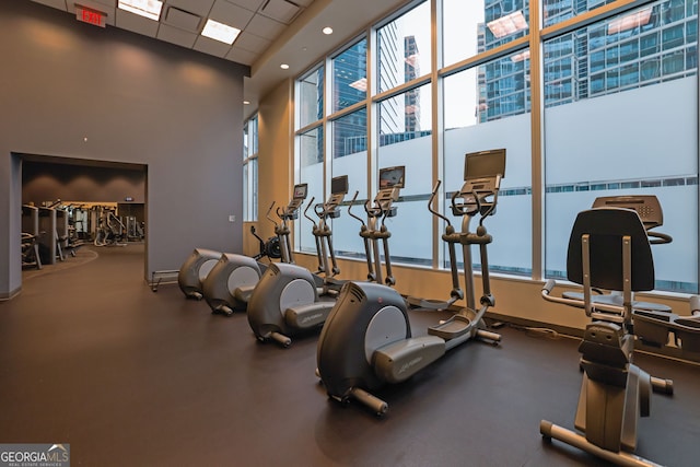 gym featuring a drop ceiling and a towering ceiling