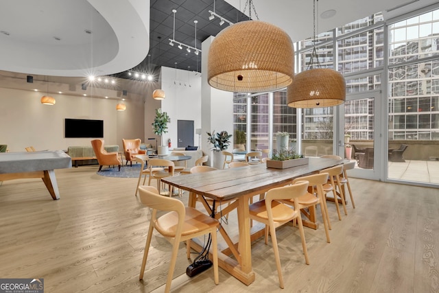 dining room featuring a high ceiling, expansive windows, and hardwood / wood-style floors