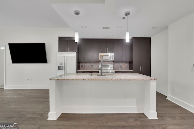 kitchen with appliances with stainless steel finishes, hanging light fixtures, dark brown cabinetry, and a center island with sink