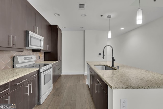 kitchen with sink, an island with sink, hanging light fixtures, and white electric range