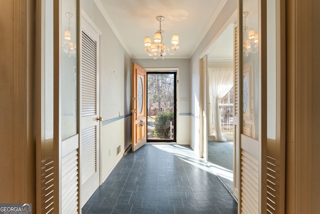 doorway with ornamental molding and a notable chandelier