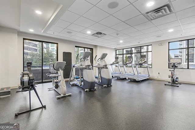 workout area with a paneled ceiling and a healthy amount of sunlight