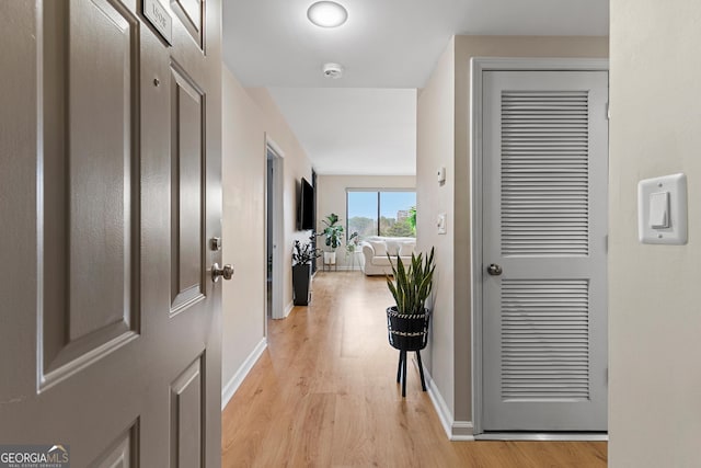 hallway with light hardwood / wood-style floors