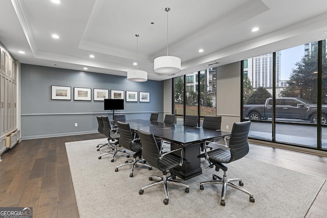 office space with a raised ceiling, crown molding, hardwood / wood-style flooring, and a healthy amount of sunlight