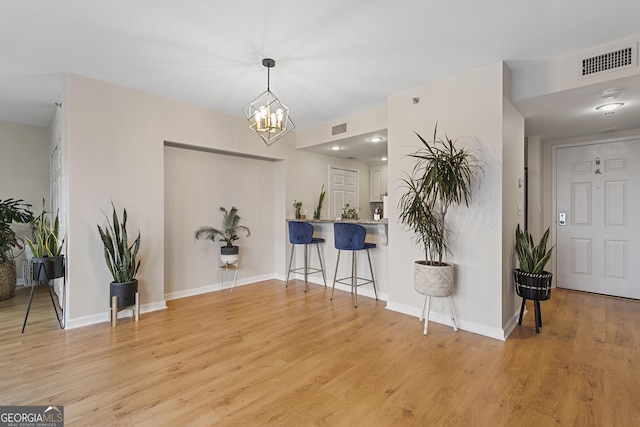 interior space with an inviting chandelier and light hardwood / wood-style floors