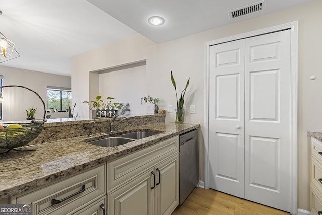 kitchen featuring light hardwood / wood-style floors, sink, stainless steel dishwasher, and dark stone counters