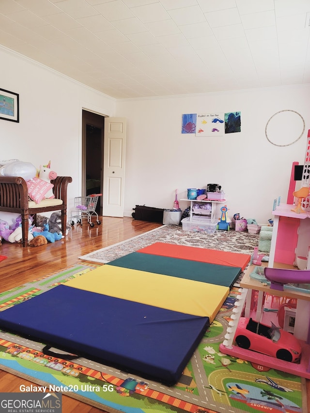 game room featuring ornamental molding and wood finished floors