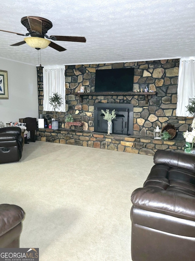 carpeted living room with ceiling fan, a fireplace, and a textured ceiling