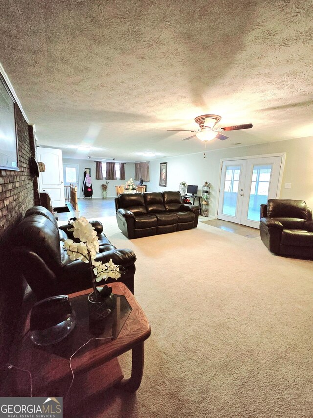 living room with ceiling fan, carpet, and a textured ceiling