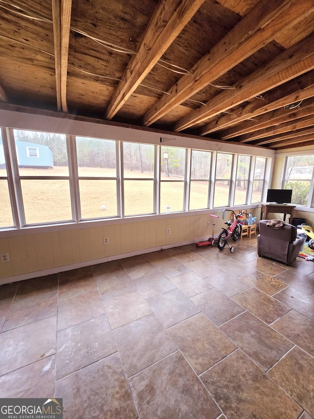 unfurnished sunroom with beamed ceiling