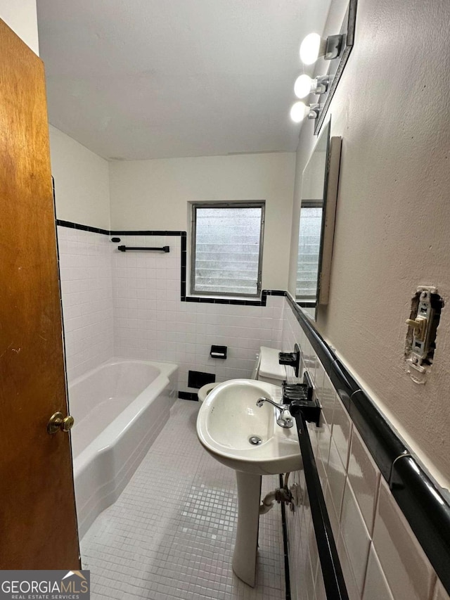 bathroom featuring sink, tile patterned flooring, and tile walls