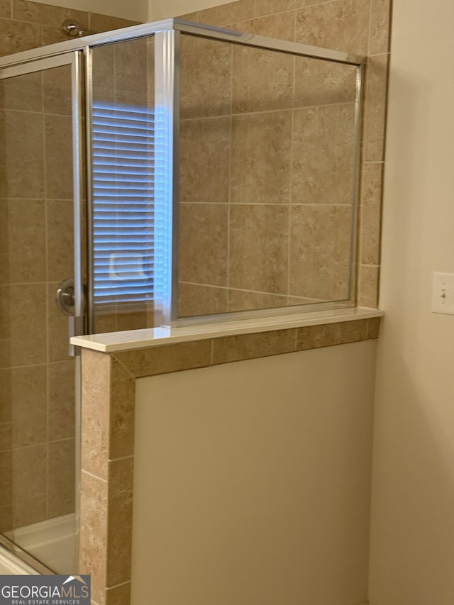 bathroom with a shower with door