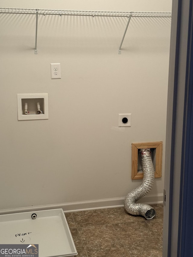 laundry room with electric dryer hookup, dark tile patterned flooring, and hookup for a washing machine