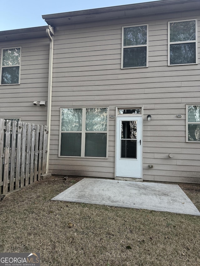 back of property with a patio area and a lawn