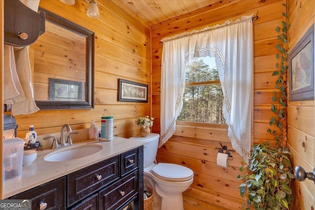 bathroom with wood ceiling, vanity, toilet, and wood walls