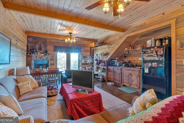 living room featuring beam ceiling, wooden walls, wooden ceiling, and ceiling fan