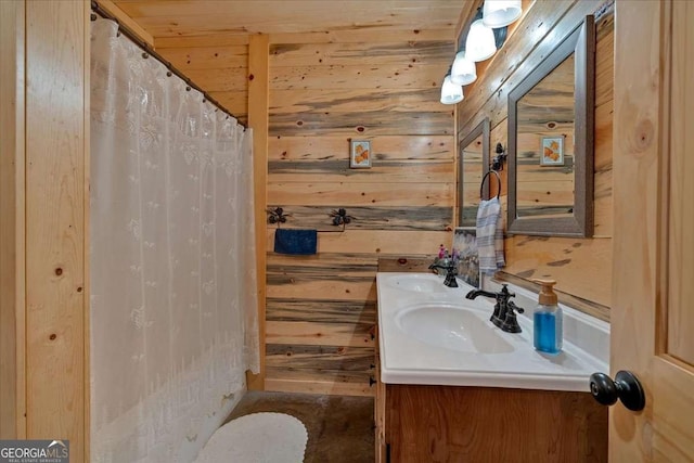 bathroom featuring vanity and wooden walls