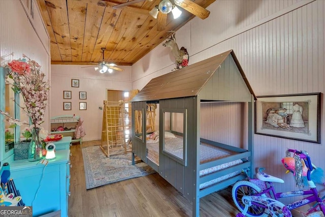 bedroom featuring wood ceiling, wood-type flooring, and wooden walls