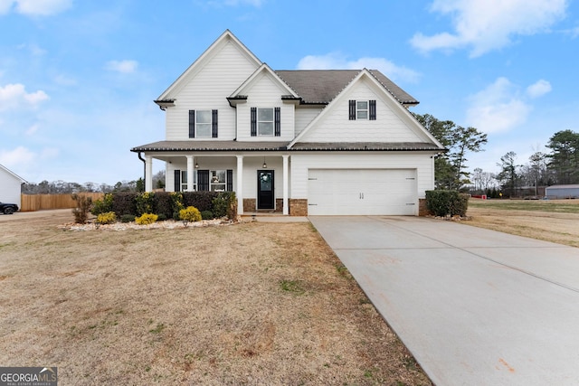 view of front of property featuring a porch, a garage, and a front yard