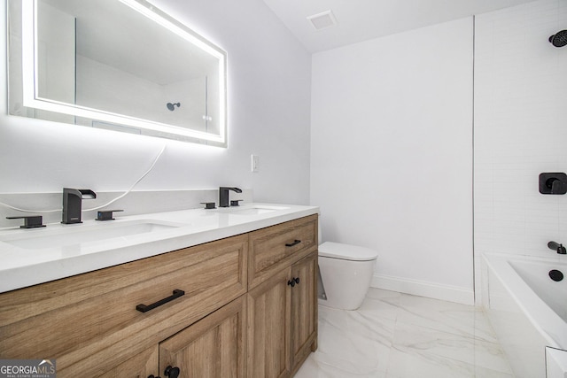 full bathroom with vanity, tiled shower / bath, and toilet