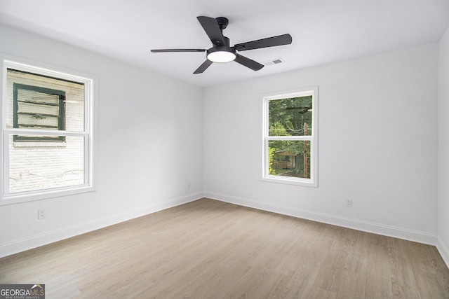 empty room featuring light hardwood / wood-style flooring, a wealth of natural light, and ceiling fan