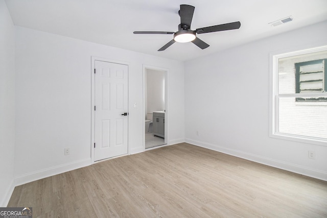 unfurnished bedroom featuring ensuite bathroom, ceiling fan, and light hardwood / wood-style flooring