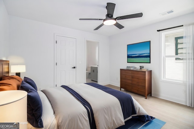 bedroom with ceiling fan, connected bathroom, multiple windows, and light wood-type flooring