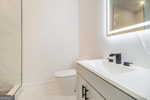 bathroom featuring vanity, toilet, and tiled shower