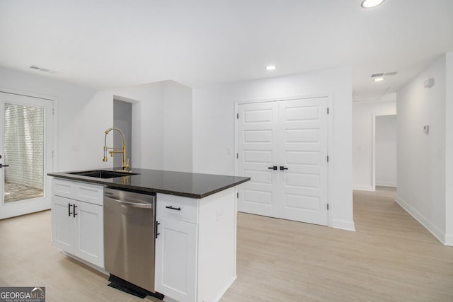 kitchen featuring sink, light hardwood / wood-style flooring, stainless steel dishwasher, a kitchen island with sink, and white cabinets