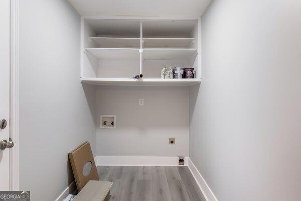 laundry area with hookup for a washing machine, hookup for an electric dryer, and light hardwood / wood-style flooring