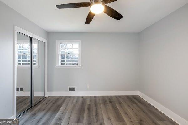 unfurnished bedroom with hardwood / wood-style floors, a closet, and ceiling fan